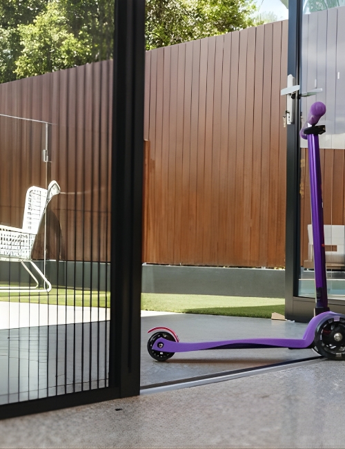 Pleated fly screen across an open doorway with a scooter outside